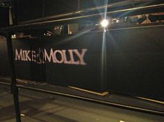 there is a sign that says mike and moly on it at night time,