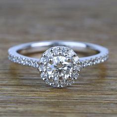 an oval cut diamond ring on top of a wooden table