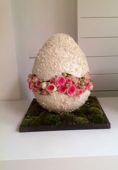 an egg decorated with flowers and moss