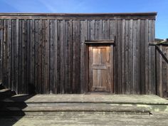 an old wooden building with steps leading up to it and a door on the side