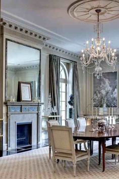 an elegant dining room with chandelier and fireplace