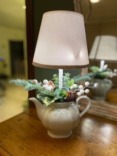 a lamp that is sitting on top of a table next to a potted plant