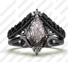 a ring with black diamonds on it and an intricate design in the middle, set against a white background