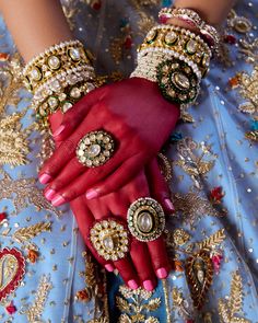 a close up of a person's hands wearing jewelry