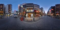 an image of a city street with buildings and people on the sidewalks at night time