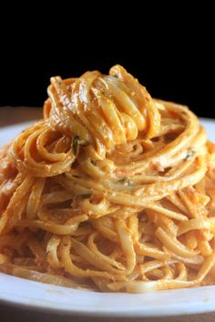 a white plate topped with pasta covered in sauce