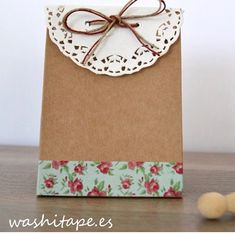 a brown paper bag with a white doily on it and red flowers around the edge