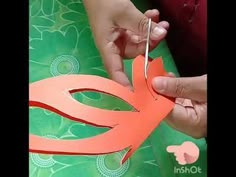 someone cutting out an origami flower with scissors