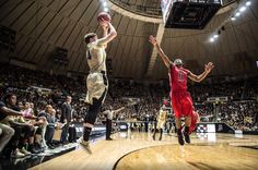 two men playing basketball in an indoor arena