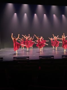 a group of dancers performing on stage with spotlights in the backgrounnd