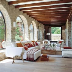 a living room filled with lots of furniture next to an open window covered in wood