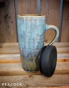 a coffee cup with a lid sitting on top of a wooden table