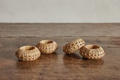 three wicker vases sitting on top of a wooden table next to each other