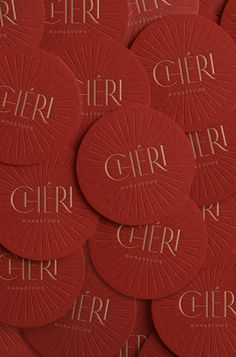 red circular coasters with the word girl printed on them in gold foiled lettering