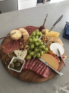 a wooden plate topped with lots of different types of cheese and meat