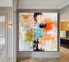 an abstract painting is hanging on the wall