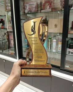 a person holding up a trophy in front of a store