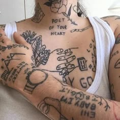 a woman with lots of tattoos on her chest and arms is holding a cell phone