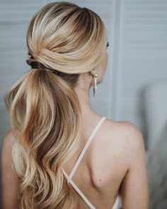 a woman with long blonde hair in a low ponytail