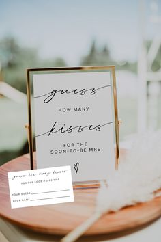 a close up of a table with a sign and some feathers on top of it