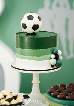 a cake with a soccer ball on top and cookies in the bottom, along with other desserts