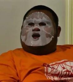 a man in an orange shirt with a face mask on