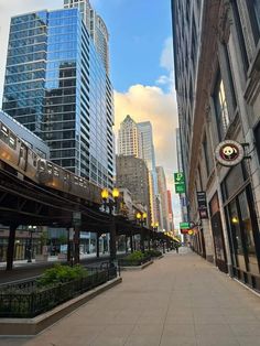 a train traveling down tracks next to tall buildings in a city with lots of windows