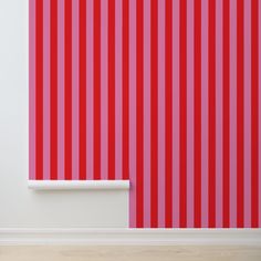 an empty room with red and white striped wallpaper on the walls next to a shelf