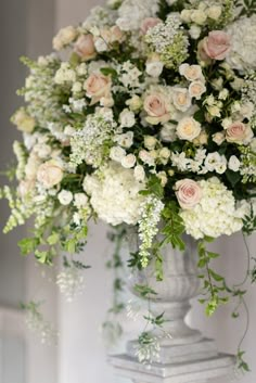 a vase filled with lots of white and pink flowers