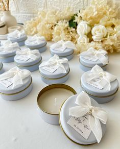 wedding favors are arranged on a table with flowers in the backgrouf and candles