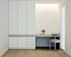 an empty kitchen with white cabinets and grey counter tops on the wall next to a dining room table