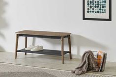 a wooden table sitting on top of a rug next to a basket filled with shoes