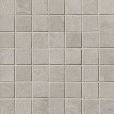 a white tile wall with grey squares on it