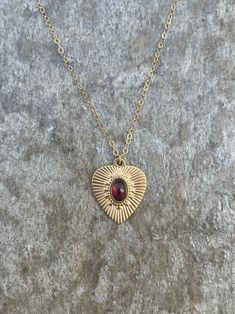 This necklace is handcrafted with an authentic 4x6mm garnet stone in a 19x16mm 14k gold-plated stainless steel setting. The stone is AAA quality. The chain is 14k gold-filled and will not tarnish easily.  This necklace is hypoallergenic. (Cadium free, lead free, and nickel safe) Garnet is an energizing stone that promotes passion and love.  The necklace comes in a ribbon-wrapped box, ready to be gifted. If you would like to leave a note for the recipient, you can do so during checkout. Valentine's Day Tarnish Resistant Brass Jewelry, Adjustable Gold-plated Heart Necklace, Adjustable Heart-shaped Gold-plated Necklace, Adjustable Heart-shaped Gold Plated Necklace, Adjustable Gold Plated Heart Necklace, 14k Gold Filled Adjustable Chain Jewelry For Valentine's Day, Gold Oval Necklace With Heart Charm, Valentine's Day Brass Heart Pendant Jewelry, Gold Oval Garnet Necklaces