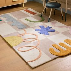 an area rug with various shapes and colors on the floor in a child's room