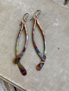 Solid copper hand-hammered into curving drops have been flame-painted with a lovely rainbow pattern.  These earrings are lightweight despite their size.Color will appear brighter in outdoor lighting. 4” drop from hypoallergenic niobium earwires Handmade in NY Artsy Nickel-free Copper Earrings, Multicolor Soldered Dangle Earrings, Artsy Multicolor Teardrop Jewelry, Artistic Multicolor Copper Jewelry, Multicolor Nickel-free Copper Earrings, Nickel-free Multicolor Copper Earrings, Multicolor Copper Dangle Earrings, Artsy Teardrop Jewelry With Matching Earrings, Artistic Multicolor Dangle Earrings