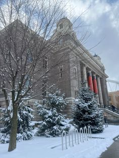 a large building with trees and snow on the ground