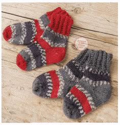 two pairs of knitted mittens sitting on top of a wooden floor next to each other