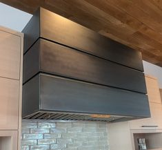 a kitchen with stainless steel hood and cabinets