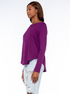 Shrunken Long Sleeve Bateau Neck Shirttail Tee. In Our Signature Slub Fabrication. Made in the USA. Model is wearing a size Small Purple Cotton Top For Layering, Stretch Long Sleeve Tops For Casual Wear, Stretch Long Sleeve Top For Casual Gatherings, Purple Crew Neck Top For Layering, Purple Relaxed Fit Long Sleeve Top, Purple Long Sleeve Relaxed Fit Top, Purple Relaxed Fit Crew Neck Blouse, Purple Relaxed Fit Top For Fall, Essential Tops