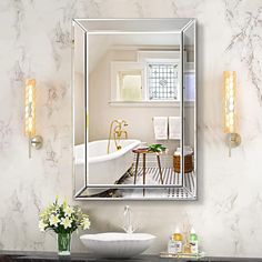 a bathroom with a sink, mirror and bathtub on the wall next to it