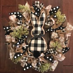 a black and white wreath with polka dots, green moss and a bunny on it