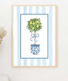 a blue and white potted plant with yellow flowers in it on a striped wall