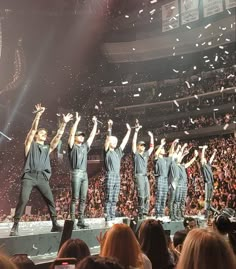 a group of men standing on top of a stage with confetti in the air