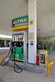 a gas station with two green and yellow pumps