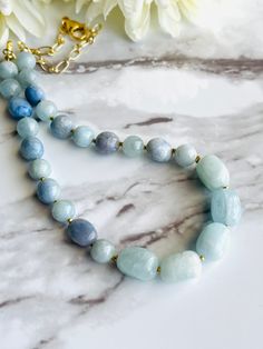 "Oh these gorgeous blues!! She is a fabulous mix of 8mm Aquamarine, Blue Aventurine pebbles and incredible 13mm Aquamarine nuggets with 2mm Ethiopian Brass Heishi between each stone!! Casual or all dressed up, she's wonderful! Necklace is 17\" long Chain is Gold electroplated cable chain  Clasp is a 15mm Lobster Claw All metal is nickel and lead free" Aquamarine Necklaces With Round Beads Of Natural Stones, Aquamarine Necklace With Natural Round Beads, Aquamarine Necklace With Round Natural Stone Beads, Aquamarine Necklace With Round Natural Stones, Blue Amazonite Necklace With Faceted Beads, Blue Amazonite Gemstone Beads Necklace, Blue Amazonite Necklaces For Jewelry Making, Blue Amazonite Jewelry With Faceted Beads, Blue Single Strand Amazonite Beaded Necklaces