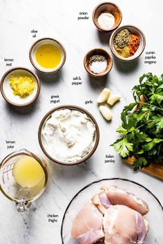 ingredients to make an appetizer laid out on a marble counter top, including raw chicken