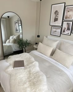 a bedroom with a bed, mirror and pictures on the wall in front of it