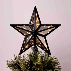 a lighted star on top of a christmas tree