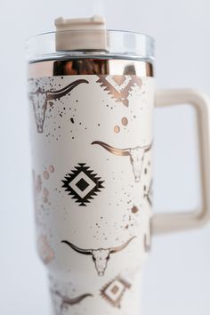 a white coffee cup with brown designs on it